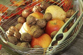 Apples, pears and walnuts on a rustic wooden table as an autumnal motif