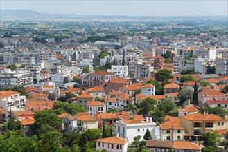 Panoramic view of a city with dense buildings and green areas under a cloudy sky, Xanthi, Eastern