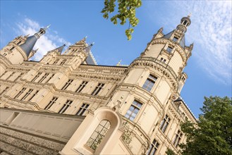 Schwerin Castle on a sunny day in summer with blue sky and white clouds, castle lake facade, in the