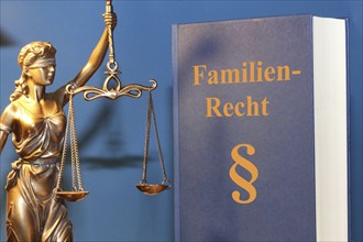 Symbolic image: Reference book on family law and a Justitia