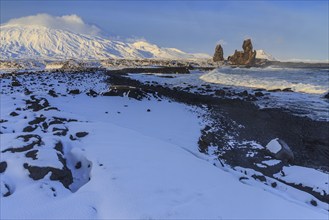 Rocks and surf at the coast, evening light, sun, snow, winter, Arnarstapi, Snaefellsjökull,