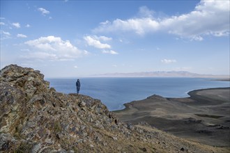 Tourist standing on a hill, view of mountain lake Song Kul, Naryn region, Kyrgyzstan, Asia