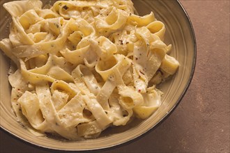 Fettuccine, tagliatelle, in creamy garlic sauce, Italian traditional cuisine, pasta carbonaro