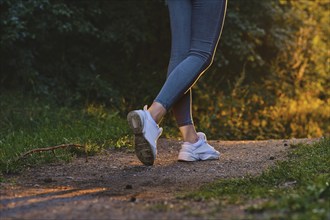 Closeup view of female hiker feet walking on forest trail