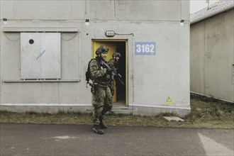 Two soldiers move during a simulated house-to-house battle, taken as part of a Bundeswehr exercise