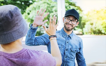 Two smiling friends shaking hands on the street. Friends shaking hands outdoors. Concept of two