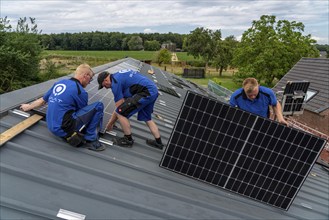 Installation of solar modules on the roof of a barn on a farm, over 240 photovoltaic modules are