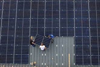 Installation of solar modules on the roof of a barn on a farm, over 210 photovoltaic modules are