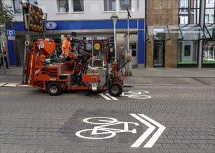 Application of road markings for a cycle lane, Rüttenscheider Straße in Essen, in the shopping and