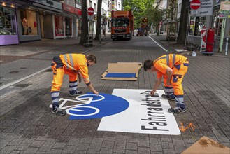 Application of road markings for a cycle lane, Rüttenscheider Straße in Essen, in the shopping and