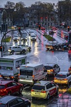 Rainy weather, road traffic, intersection, lights of vehicles on a wet road, traffic lights, tail