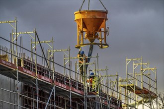 Concrete work, at dusk, on a large construction site building a residential and commercial complex,