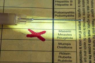 Symbolic photo measles vaccination, vaccination certificate, syringe with measles vaccine