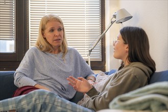 Mother and daughter, teenage, 13 years old, in a confidential conversation, at home