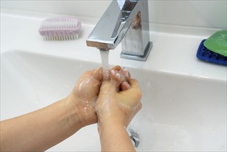 Domestic hygiene, washing hands, with a bar of soap, boy 9 years old