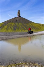 Cyclist on the Rheinelbe spoil tip in Gelsenkirchen, 100 metre high spoil tip, landscape park, with