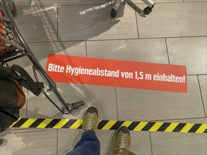 Effects of the corona crisis in Germany, sticker on the floor informs customers of a supermarket