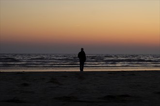 Sunrise on the Baltic Sea beach near Karlshagen, man with camera, September, Usedom,