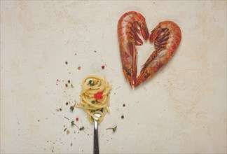 Spaghetti wrapped on a fork, langoustines heart shape, on the table, food concept, food background,