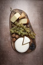 Georgian cheese, Imeretian and smoked suluguni, grapes, nuts, on a cutting board, Georgian cuisine,