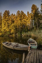 Boats in the autumnal Schmutter Weiher in the Allgäu near the municipalities of Halblech,