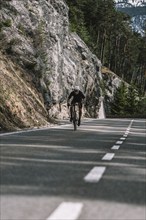 Road bike rider in spring in the Allgäu against the picturesque backdrop of the Alps, Bavaria,