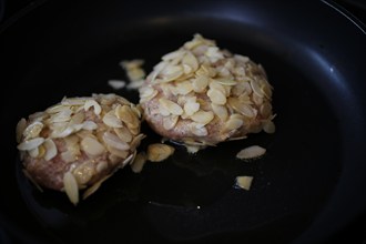 Swabian cuisine, meatballs wrapped in almonds, mixed minced meat, raw, frying meatballs in fat,