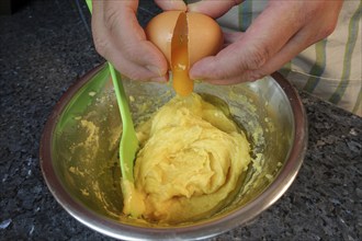 Swabian cuisine, preparing choux pastry for mini cream puffs, adding egg to raw choux pastry,