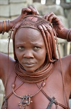 Himba woman arranging her hair, Opuwo, Kaokoland, Kunene, Namibia, Africa