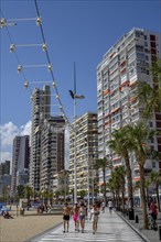 Tourists on the beach promenade at Playa Levante, Benidorm, Alicante province, Costa Blanca, Spain,