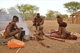 Chief Hikuminue Kapika, tribal leader of the Namibian Himba people, sitting with his family at a