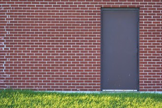 Brick wall with rectangular door and a meadow in front of it, Ontario, Canada, North America