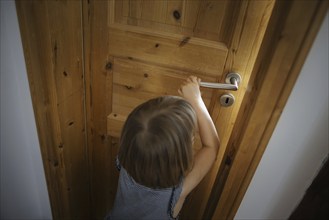 Symbolic photo: A small child opens a door in a flat. Berlin, 21.08.2024