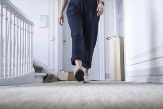 A woman leaves a parcel on her neighbour's doorstep in Berlin, 08.08.2024