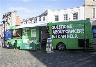 Macmillan Cancer Support green bus in the town centre of Chippenham, Wiltshire, England, United