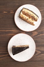 Chocolate biscuit cake with caramel cream on brown wooden background. top view, flat lay