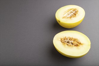 Sliced ripe yellow melon on gray pastel background. Side view, copy space. harvest, women health,