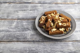 Cheese and toast on a gray plate on a gray wooden background. Side view, close up, copy space