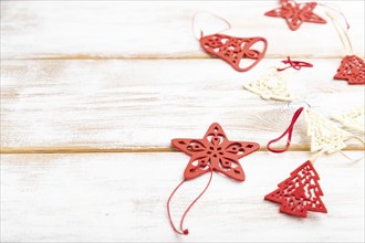 Christmas or New Year composition. Decorations, red stars, bells, on a white wooden background.