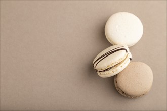 Brown and white macaroons on beige pastel background. top view, flat lay, copy space, still life.