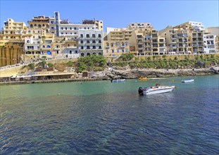 Waterfront hotel buildings beach and sea at Xlendi, island of Gozo, Malta, Europe