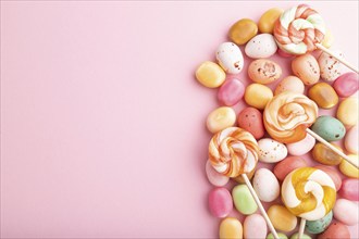 Various caramel candies on pink pastel background. copy space, top view, flat lay