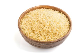 Wooden bowl with raw golden rice isolated on white background. Side view, close up