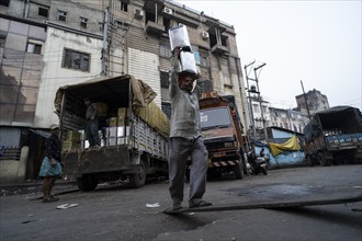 Labourer carries good from truck at a wholesale market, ahead of the presentation of the Interim