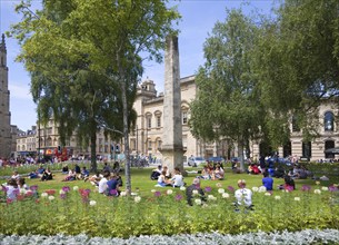 People enjoying summer sunshine on the grass at Orange Grove, Bath, Somerset, England, United