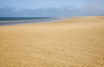 Small waves breaking on wide sandy beach at Hunstanton, north Norfolk coast, England, United