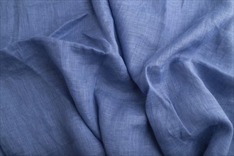 Fragment of blue linen tissue. Top view, natural textile background and texture. wave concept,