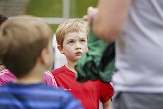 Child listens to a coach on the football pitch, Bonn, 19.06.2024