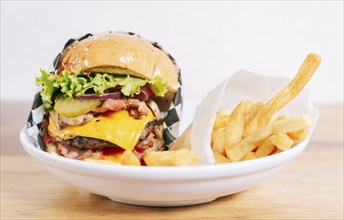 Cheeseburger with fries on wooden table. Close up of a delicious hamburger with french fries on