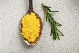 Yuzu caviar is pearly, on a spoon, top view, light background, no people.